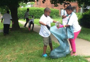 Two children pick up garbage outside